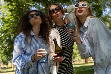 Fototapeta premium Art picnic in spring drinking wine, laughing, taking pictures on polaroid and having a great time with friends having delicious snacks 