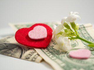 Red hearts and dollars. The concept of love for money. close-up.