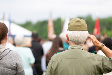 Veteran saluting flag at outdoor event