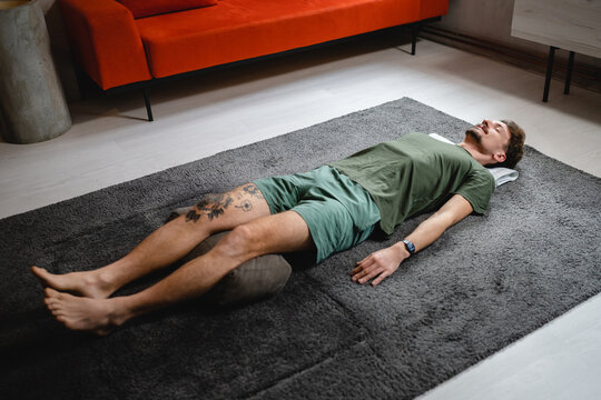 One modern caucasian man adult male practice restorative yoga at home