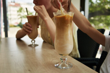 Children drinking latte coffee at a cafe in summer