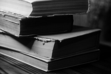a stack of old books in monochrome photography