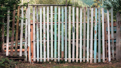Obraz premium Old wooden rustic color fence, property border with nature background