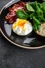 poached egg breakfast bacon, green leaves salad mix healthy meal food snack on the table copy space food background rustic top view