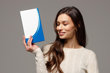 A beautiful young girl with glowing skin holds cosmetic preparations in her hands. Concept of healthy skin and cosmetology.