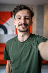 One man young adult caucasian male standing at home with brown hair mustaches and beard looking to...
