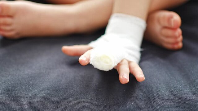 Little girl with broken finger on sofa at home on sick leave