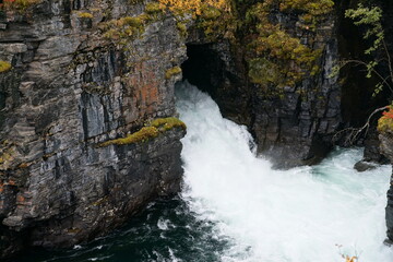 Fototapeta na wymiar River in Abisko, Sweden in a canyon with steep rock walls and with water from a man made tunnel