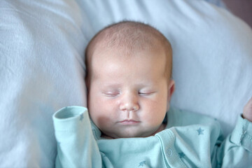 the newborn boy is sleeping. cute beautiful baby is sleeping closeup portrait of a beautiful sleeping baby on white.