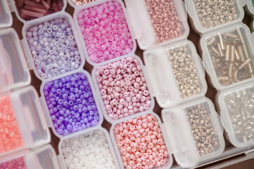 Colorful beads in plastic box organizer closeup. Handmade and hobby materials.