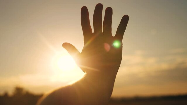 girl stretches out her hand in the sun. faith in god dream a religion sunlight concept. hand in sun the close-up silhouette dream of happiness
