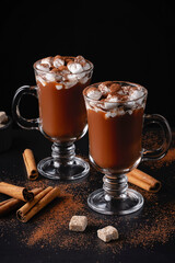 Two cups of hot chocolate, cocoa or warm drink with marshmallows on dark background
