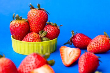 Fresas maduras y frescas en fondo azul.