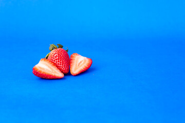 Fresas maduras y frescas en fondo azul.