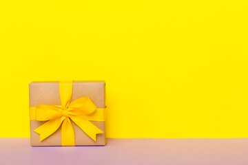holiday paper present tied yellow ribbon bow top view with copy space. Flat lay holiday background. Birthday or christmas present. Christmas gift box concept with copy space