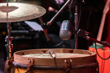 Professional percussion microphone for live sound in a Latin jazz concert indoor. Drum, bombo, intimate atmosphere.  Copy space.
