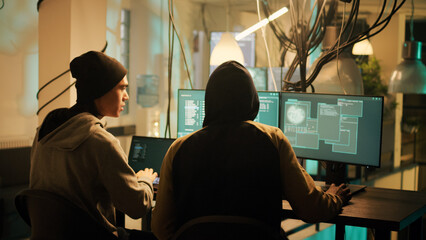 Hackers team working together to break security system on computer, stealing data and passwords....