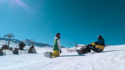 two friends snowboarding in the mountains