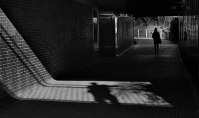 street harrasment and me too movement concept, shadow of a man and young girl in a railway station,...