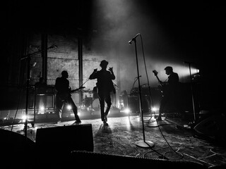silhouette of a person in a band walking up to a microphone