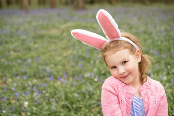 cute child wearing bunny rabbit's ears outside for Easter in spring. girl's portrait with copy space 