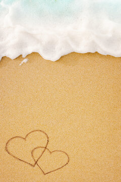 Heart symbol handwritten on sand with soft sea wave on background. Valentines Day, wedding and romantic honeymoon concept photo