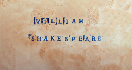The name of the great poet and playwright William Shakespeare is written in stamped letters in dark...