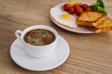 Close up cup of black coffee with homemade breakfast on the wooden table