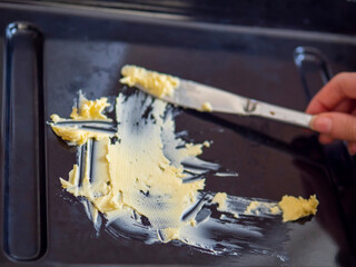 Fresh butter spread on a baking tray in abstract shape, selective focus. Cooking theme.