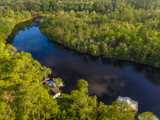 High angle view of a river in a forest with residences and green trees at Navarre, Florida....