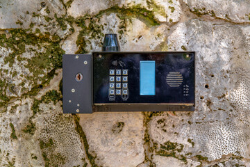 Miami, Florida- Modern keycard access on a concrete wall at the gate. Close-up of an electronic keyless lock acess mounted on a wall outside.