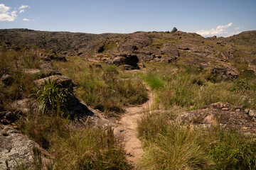 View of the empty hiking path across the grassland and hills.