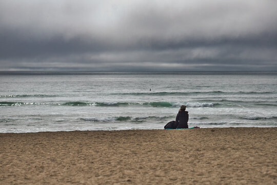 Solace on the Seashore: Woman Taking a Moment Looking Out to Pacific Ocean
