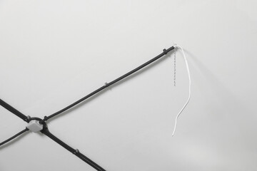 Conduits with cables on white ceiling, low angle view