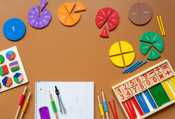 Fractions, rulers, pencils, notepad on brown background. Set of supplies for mathematics and for school.  Back to school, fun education concept	