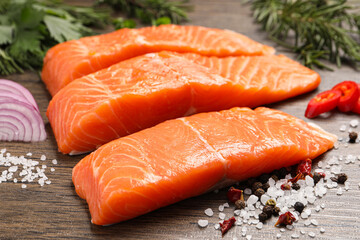 Fresh salmon and ingredients for marinade on wooden table, closeup