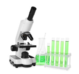 Laboratory glassware with green liquid and microscope isolated on white