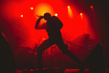 Plakat silhouette of a dancing man with a microphone in a red background
