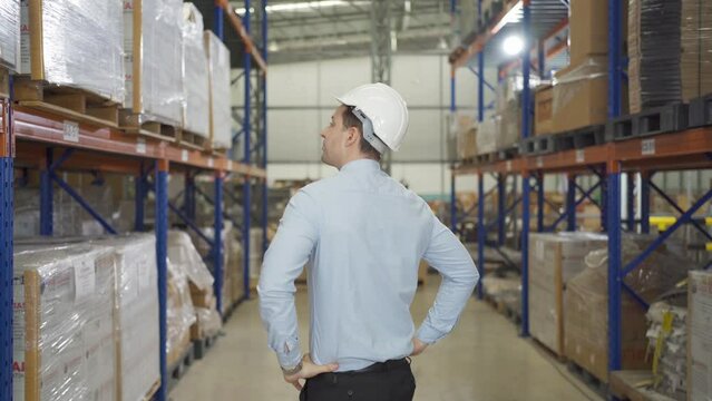 Portrait of caucasian worker working in large warehouse store industry.Rack of stock storage. Interior of cargo in logistic concept. Depot. People lifestyle. Shipment service for container