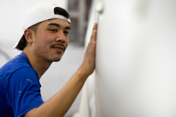 A skilled painter detailing a professional car paint primer while polishing a shiny white car, car...