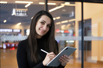 beautiful business woman using tablet computer texting while walking in corporate office building, checking e-mail messages the internet, successful executive woman.