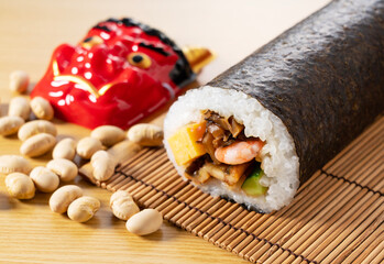 Eho-maki rolls, beans for mame-maki (bean-throwing), and demon masks on the table.