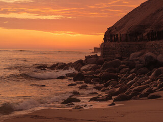 Sunset at El silencio beach, Lima, Peru. Golden hour, the ocean breaking on the rocky shore