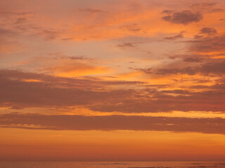 Sunset on the beach, golden hour, the sky is painted in orange and yellow colors