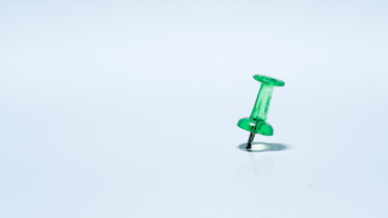 green push pin on white background