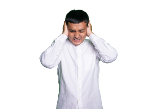 Asian man wearing a white shirt showing the expression of stress or headaches and covering the ears.