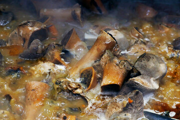 authentic veal or beef bone stock boiling in a hot large pot