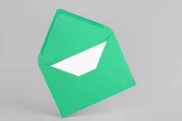 Green paper envelope with card on light background