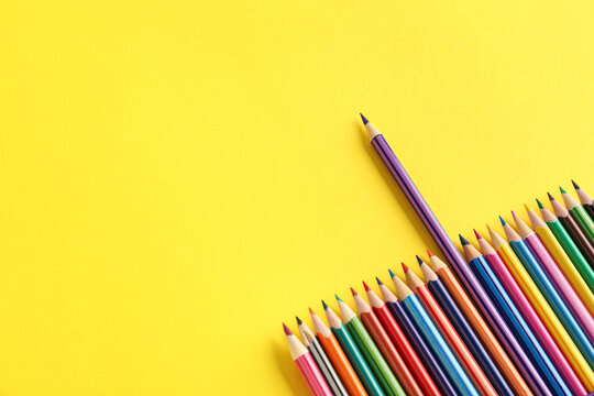 Set of colorful pencils on yellow background