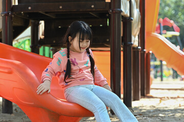 Adorable little child having fun on playground in suburb house courtyard